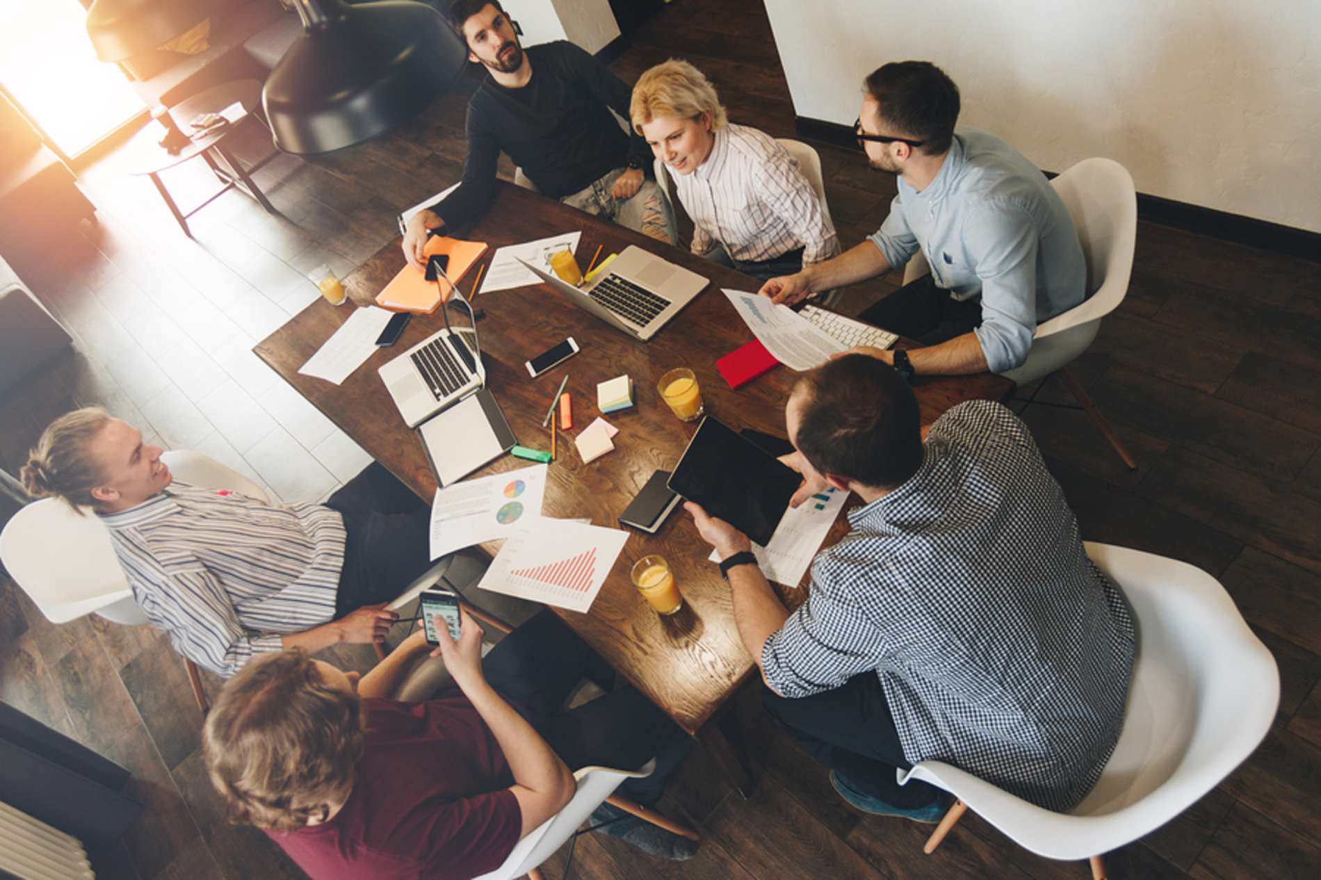 Group of colleagues discussing information around a conference table.